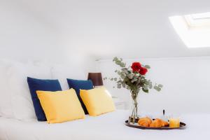 a vase with a red rose and some pillows at - Le Millésime suspendu - in Libourne
