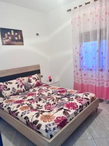 um quarto com uma cama com um edredão floral em Kristina Apartament em Saranda