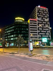 een gebouw 's nachts met een straat ervoor bij Midtown Boutique Apartment in Novi Sad