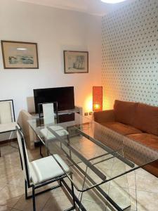 a living room with a glass table and a couch at Casa Turbigo-Malpensa-Milano in Turbigo