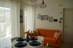 salon z pomarańczową kanapą i stołem w obiekcie Rifugio di Mare - Appartamento Vasto Marina w mieście Vasto