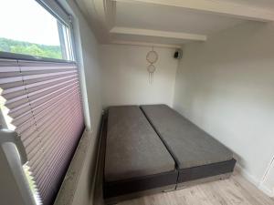 una piccola camera da letto con un letto e una finestra di DDR Datsche Veer a Boltenhagen