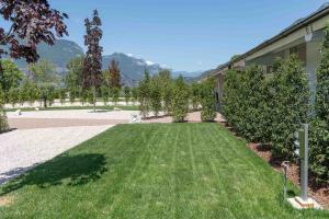 a yard with a green lawn and a building at Camping Agrisalus in Arco