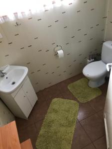 a bathroom with a white toilet and a sink at Wiejski Domek na Roztoczu 