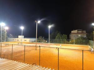 een tennisbaan verlicht in de nacht met verlichting bij Split Ruža Apartment in Split