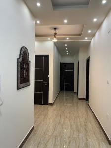 a hallway with white walls and wood floors at Modern Apartment 3 room in Sheikh Zayed N5 الشيخ زايد in 6th Of October