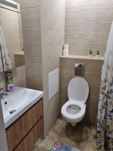 uma casa de banho com um WC branco e um lavatório. em Апартамент Медика 2 em Ruse