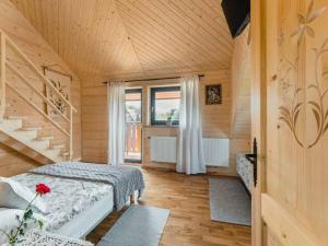 a bedroom with two beds in a wooden room at Apartamenty Bąkowo Chatka in Witów