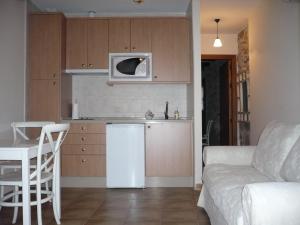 una pequeña cocina con nevera blanca y sofá en Apartamentos Turísticos Rincón de la Magdalena, en Plasencia
