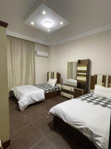 Pokój hotelowy z 2 łóżkami i lustrem w obiekcie Modern Apartment 3 room in Sheikh Zayed N5 الشيخ زايد w mieście 6th Of October (Miasto 6 października)