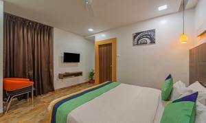 a hotel room with a bed and a tv at Treebo Trend Golden Swan Tambaram in Tambaram