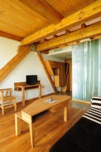 ein Wohnzimmer mit einem Sofa und einer Holzdecke in der Unterkunft Vasaknų dvaras in Žabičiūnai