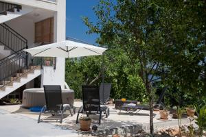 a patio with two chairs and an umbrella at Apartment Tanja in Imotski