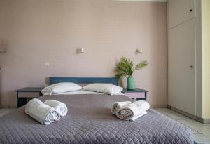 a bedroom with two beds with towels on them at Sofia's Hotel in Kalamaki