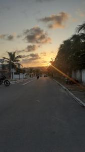 an empty street with a sunset in the distance at Cantinho da Tia Lucia in Beberibe