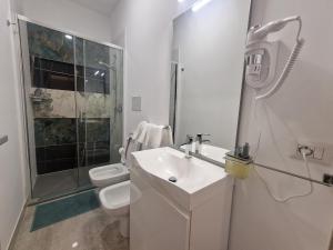 y baño blanco con lavabo y ducha. en b&b sirena camera moderna, en Francavilla al Mare