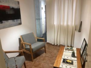 un soggiorno con sedia e tavolo di Cómodo y cálido a Buenos Aires