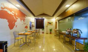 a restaurant with tables and chairs and a map on the wall at Treebo Trend Golden Swan Tambaram in Tambaram