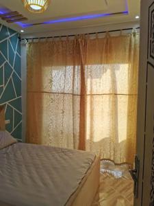 a bedroom with a bed and a window at Appartement aboubakr ahayek in Chefchaouen