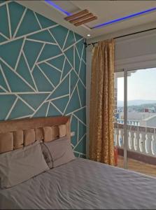 a bedroom with a large bed and a window at Appartement aboubakr ahayek in Chefchaouen