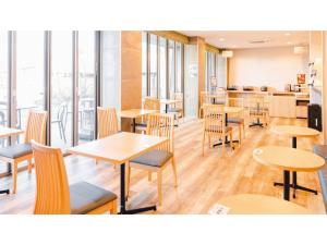 un restaurante con mesas y sillas de madera y ventanas en AIRAIKU HOTEL Kagoshima - Vacation STAY 17438v, en Aira