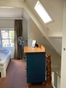 een kamer met een bed en een bureau met een raam bij Family fisherman's house Volendam in Volendam