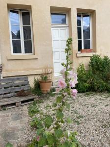 uma casa com uma porta branca e flores à sua frente em Tiers lieu de l'Ermitage em Versalhes