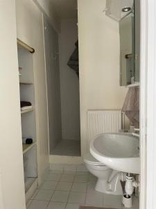 uma casa de banho com um WC branco e um lavatório. em Tiers lieu de l'Ermitage em Versalhes