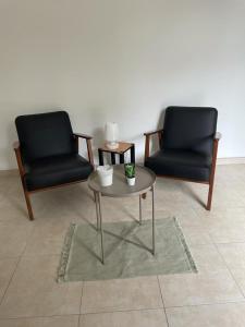 Duas cadeiras e uma mesa de centro numa sala de estar em Tiers lieu de l'Ermitage em Versalhes