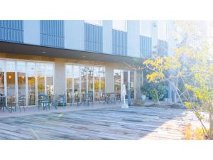 AIRAIKU HOTEL Kagoshima - Vacation STAY 17451v في Aira: مبنى به طاولات وكراسي في ساحة