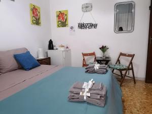 um quarto com uma cama azul com toalhas em Melissa lux em Ciampino