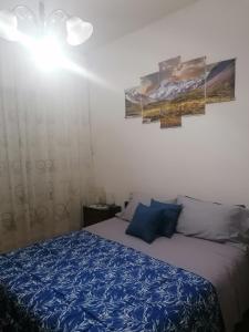 um quarto com uma cama com um edredão azul em Melissa lux em Ciampino