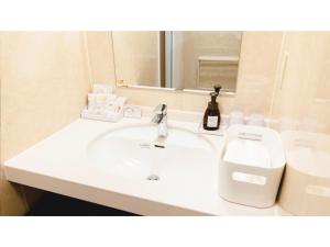 y baño con lavabo blanco y espejo. en AIRAIKU HOTEL Kagoshima - Vacation STAY 17424v, en Aira