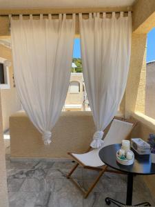 a room with a table and a white curtain at Aelia Houses in Agia Marina Aegina