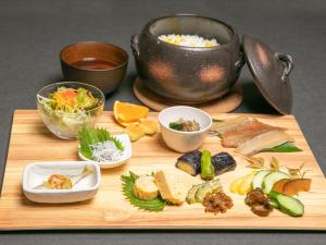 a wooden cutting board with different types of food on it at BAMBOO RESORT MIHAMA TSUNAGI - Vacation STAY 43006v in Noma