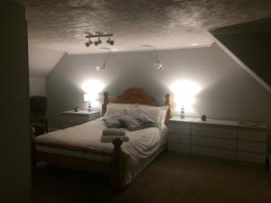 Un dormitorio con una cama con dos luces. en Thornleigh House, en Peterborough