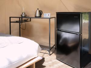 um frigorífico preto num quarto com uma mesa em BAMBOO RESORT MIHAMA TSUNAGI - Vacation STAY 43081v em Noma