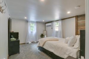 ein Schlafzimmer mit einem großen Bett und zwei Fenstern in der Unterkunft Cabin Rental Near Pennsylvania State Parks 
