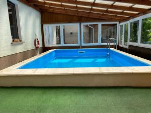 a large blue swimming pool in a house at Pension Kirschgarten in Nebra