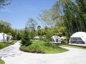 une passerelle dans un parc avec des dômes et des arbres dans l'établissement BAMBOO RESORT MIHAMA TSUNAGI - Vacation STAY 43085v, à Noma