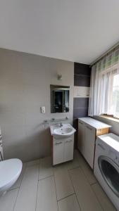 a bathroom with a sink and a washing machine at Avena in Jastrzębia Góra