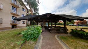 a gazebo in a park next to a building at Apartamenty i pokoje z basenem AVENA Jastrzębia Góra in Jastrzębia Góra