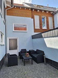 eine Terrasse mit Sofas, einem Tisch und einem Gebäude in der Unterkunft Pension Eichsfeld Zimmer 4 Standard in Breitenworbis