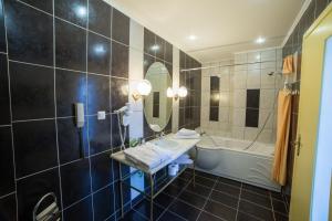 a bathroom with a sink and a tub at Delphi Art Hotel by Prima Hotels in Athens