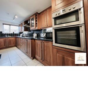 a kitchen with wooden cabinets and an oven at Monthly Offers, 7 Guests, Business, WIFI in Wyken