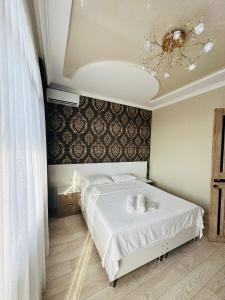 a bedroom with a bed with white sheets and a chandelier at House in Tsikhisdziri in K'obulet'i