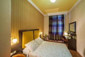 a bedroom with a bed and a desk and a window at Delphi Art Hotel by Prima Hotels in Athens
