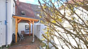a patio with a wooden pergola next to a building at Neukalener Stadthaus Zum Alten Schmied in Neukalen