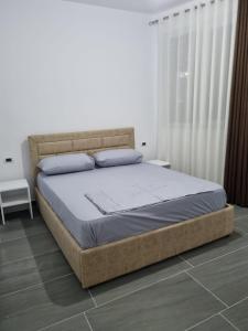 ein Schlafzimmer mit einem großen Bett in einem Zimmer in der Unterkunft Apartamente Kune Shengjin in Lezha