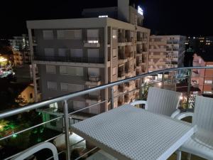 ein Tisch und Stühle auf einem Balkon in der Nacht in der Unterkunft Apartamente Kune Shengjin in Lezha